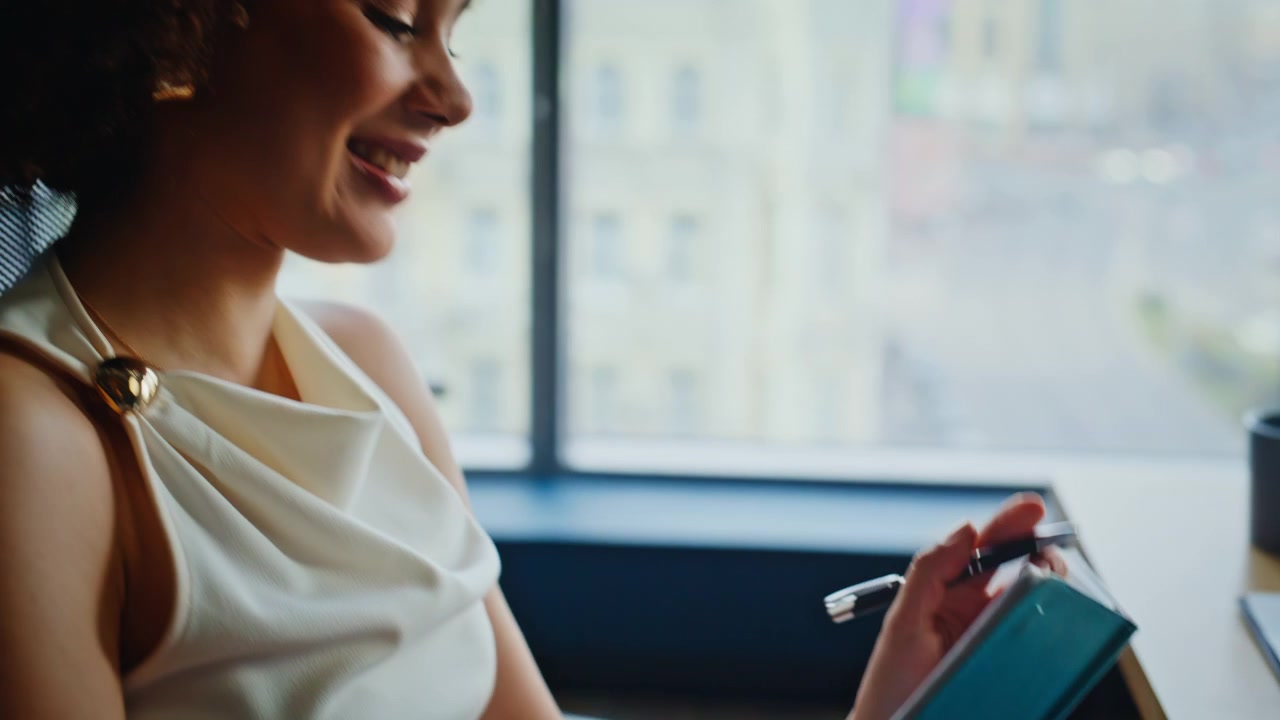 Business woman writing notes turquoise notebook office. Close up thoughtful