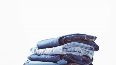 Close-up-of-folded-jeans-with-different-shades-on-white-background-with-copy-space