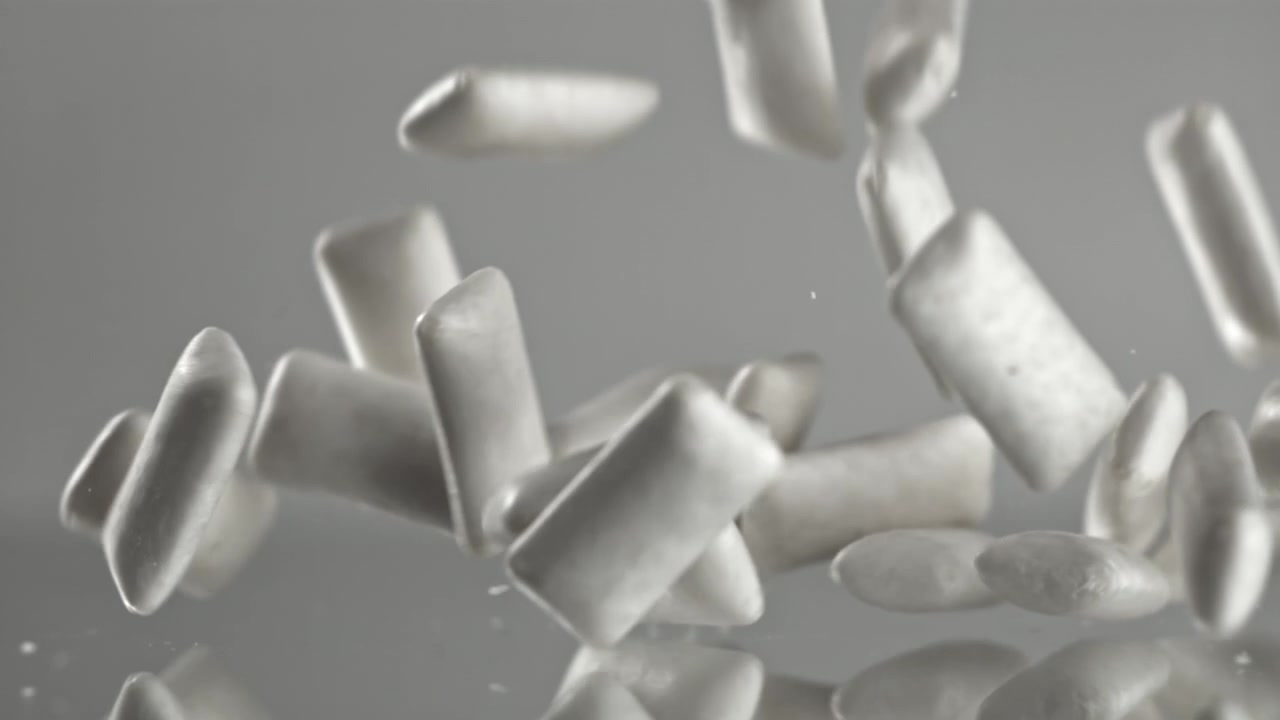 Trozos de chicle blanco cayendo en cámara lenta