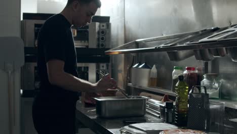 male cook stirring ingredients in kitchen