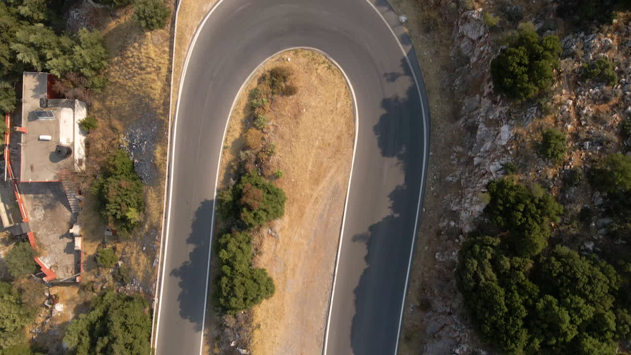 Vista dall'alto di un tornante su una strada asfaltata in montagna sull'isola di Creta, Grecia.