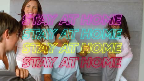 animation of four lines of colourful neon words stay at home over caucasian family having a pillow f