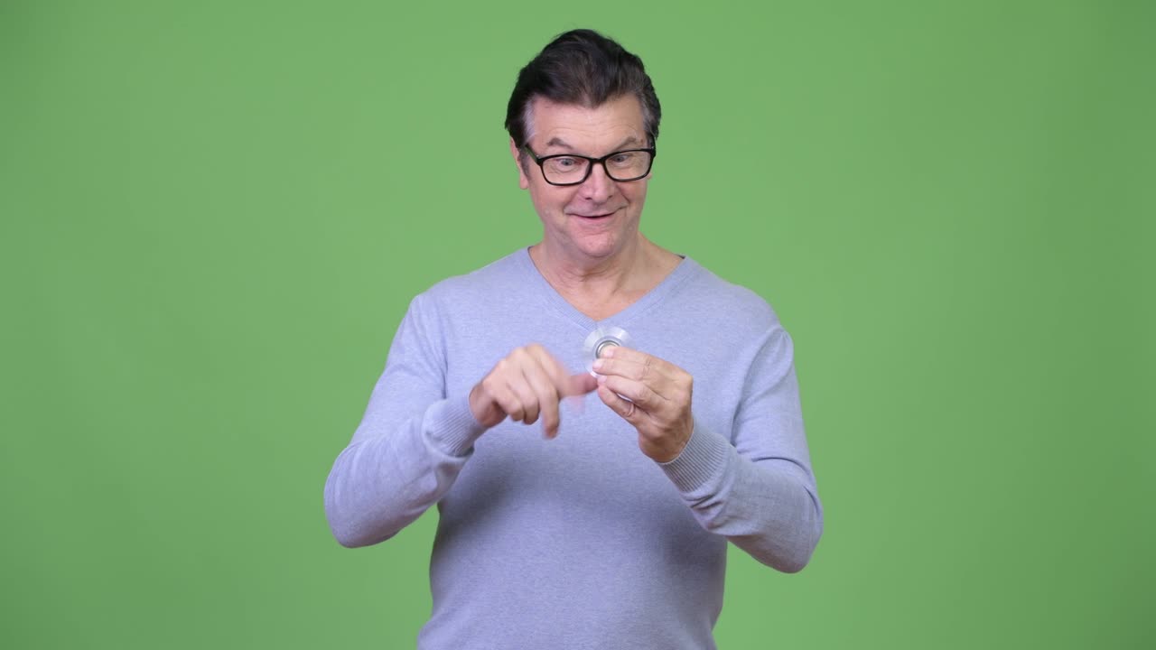 hombre guapo senior jugando con el girador inquieto