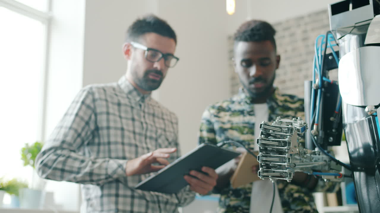 Two engineers working with a robot arm