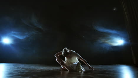 slow motion: modern ballet dancing woman barefoot lying on the floor doing spins and pirouettes and somersaults.