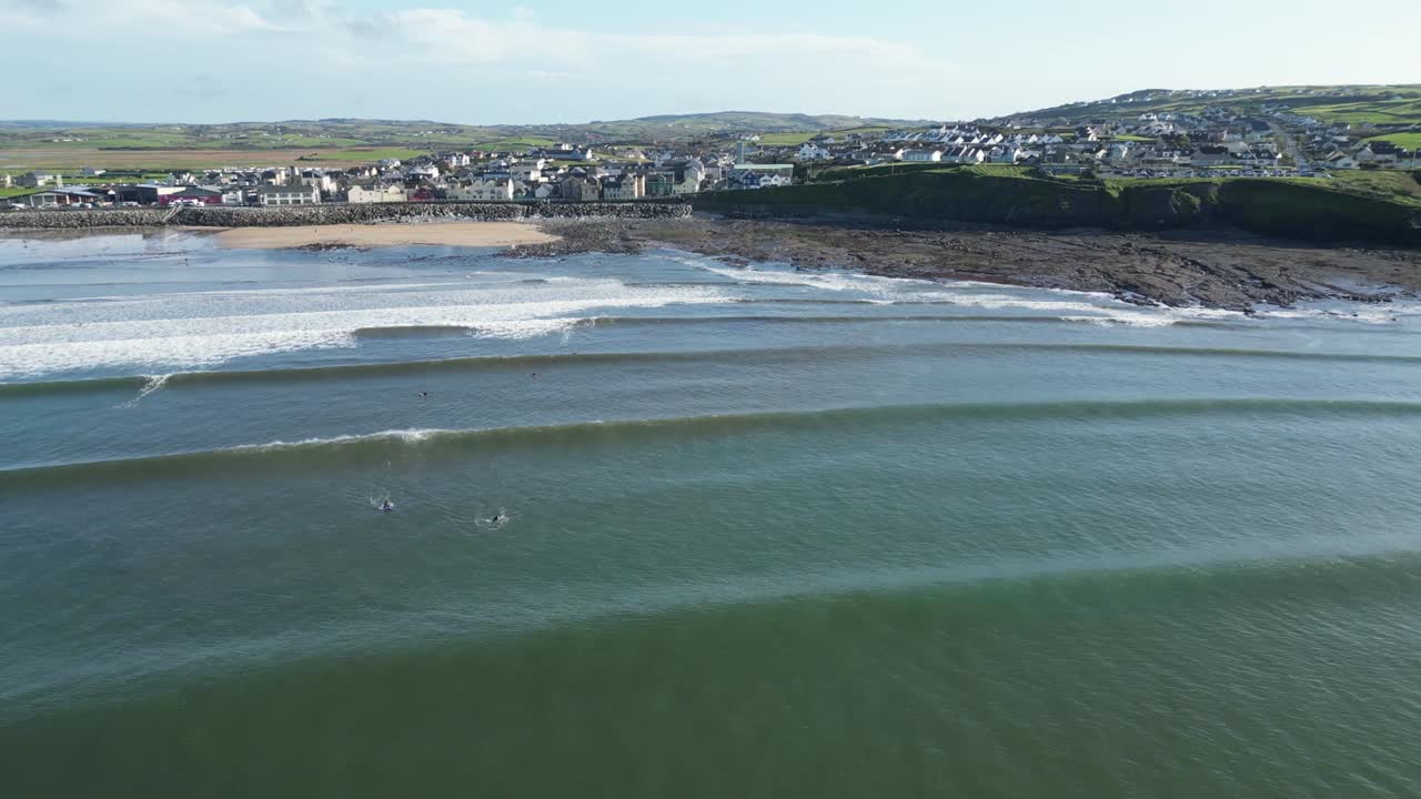 imagen aérea de surfistas esperando en la ola derecha en la playa de lahinch, irlanda.