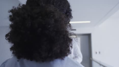 African-american-male-and-female-senior-doctors-talking-to-each-other-at-hospital