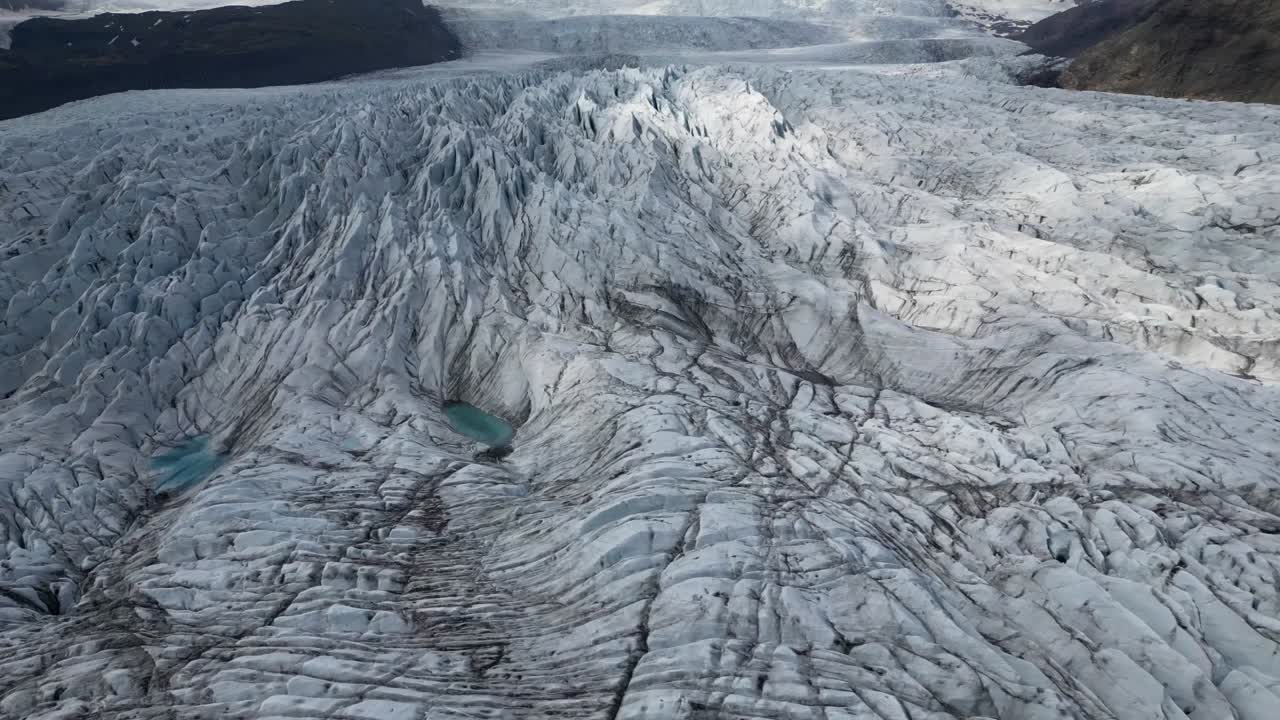 Aerial view of the Fjalls&aacute;rl&oacute;n glacier with dreamy turquoise water formations in the middle of the glacier during the summer of Iceland