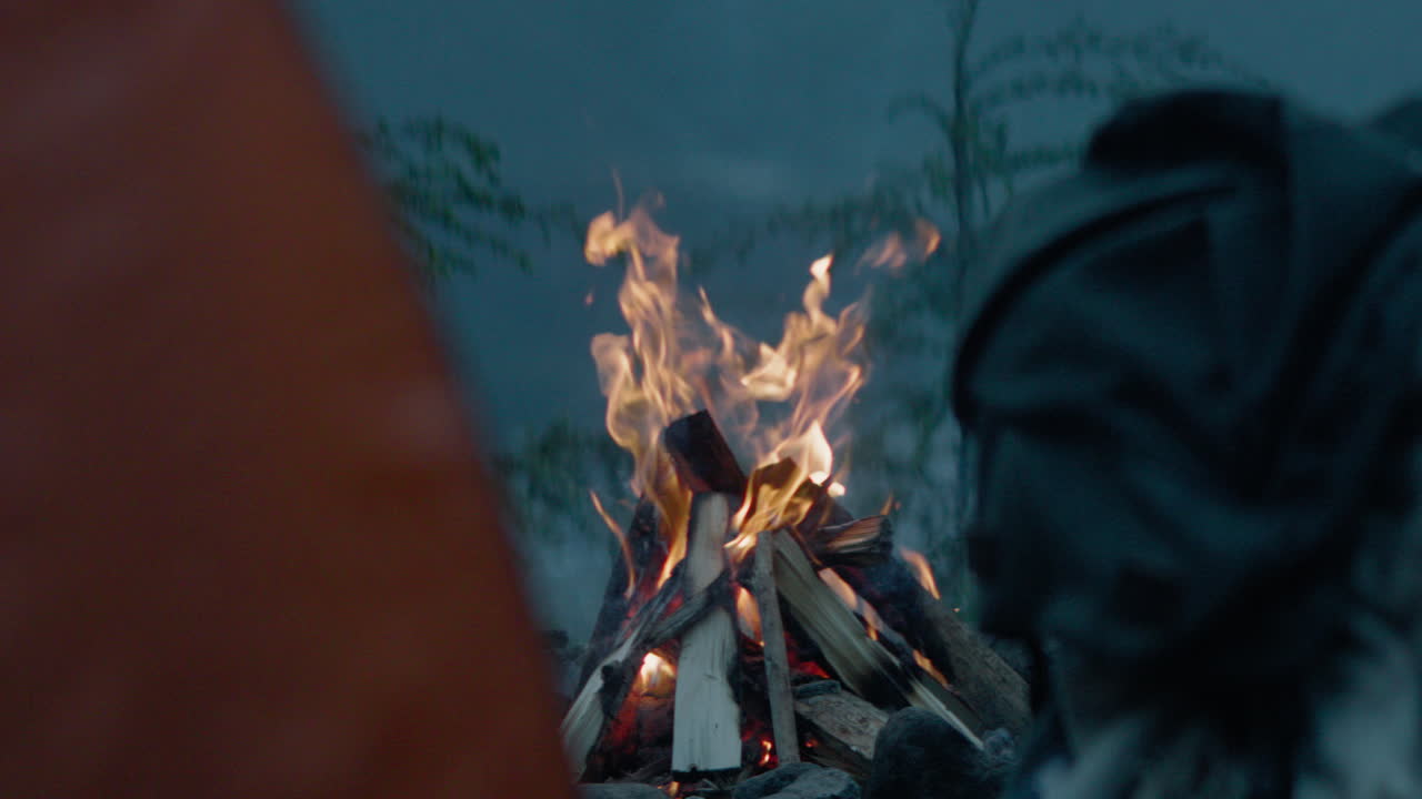 Campfire burning strong at dusk camping spot