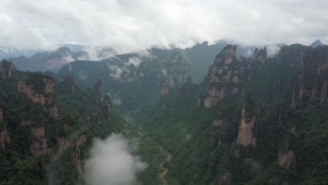 Stereotypical-misty-forest-rock-spire-valley-aerial-in-Hunan,-China
