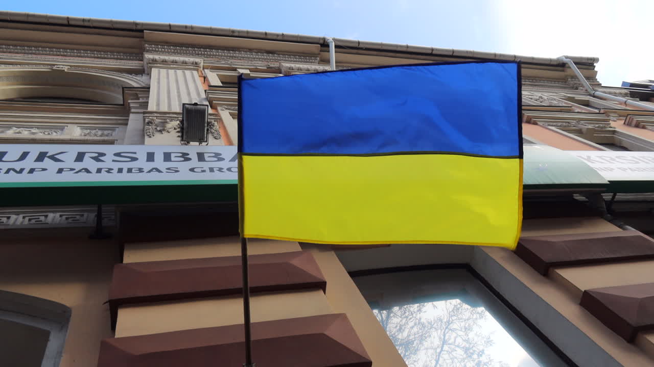 Big blue and yellow Ukrainian flag on a building in Kyiv city center Ukraine, 4K shot