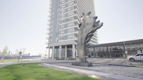 Tilt-up-shot-of-the-metal-Lake-Ontario-sculpture-outside-of-the-a-condominium-building