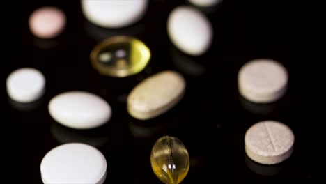 assorted pills and capsules on black surface