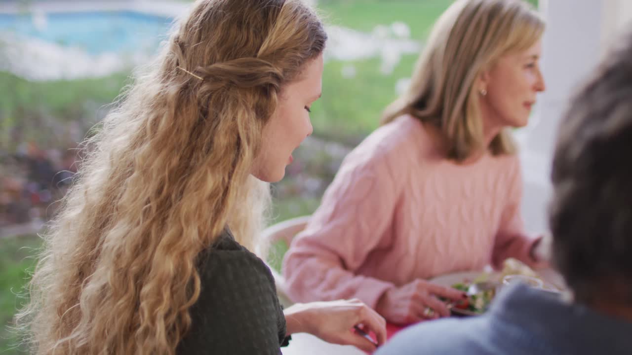 행복 한 백인 어머니 가 야외 가족 저녁 식사 테이블 에서 돌아서서 미소 짓는 영상
