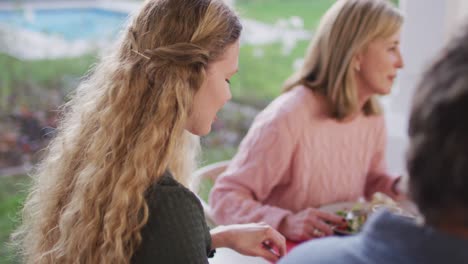 video of happy caucasian mother turning and smiling at outdoor family dinner table