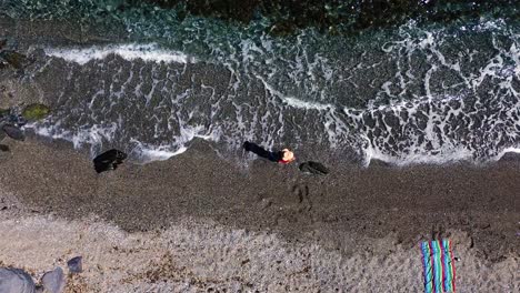 Gente-En-La-Playa-Vista-Aérea-De-Drones-Jugando-Tenis-De-Playa,-Tomando-El-Sol,-Disfrutando-De-Las-Vacaciones-En-La-Orilla-Del-Mar