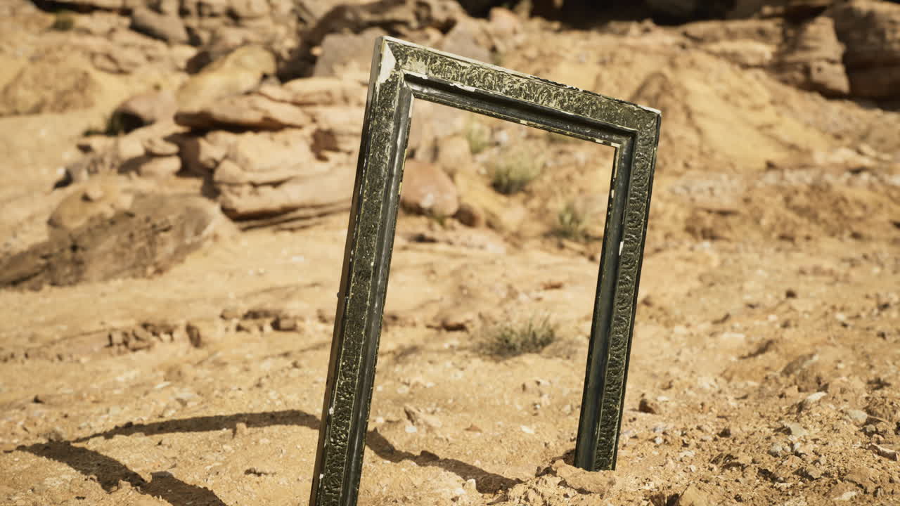 Desert landscape features an ornate frame standing amidst rocky terrain