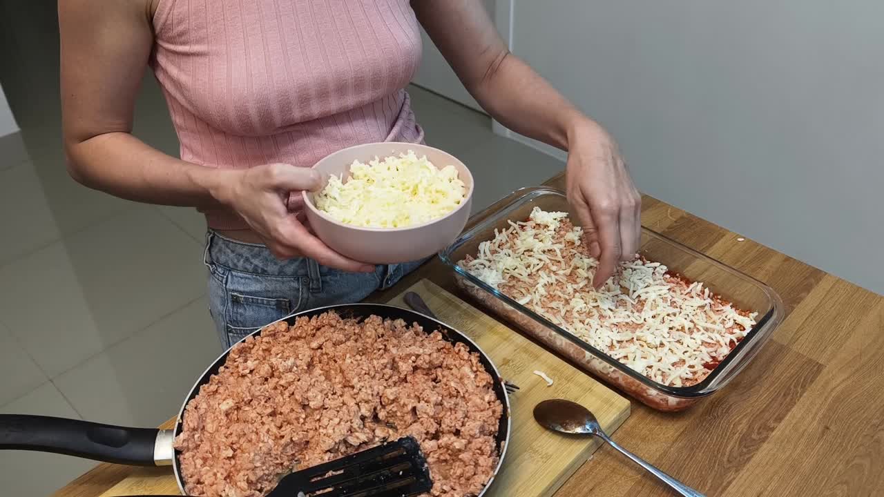 Woman preparing lasagna with meat and cheese