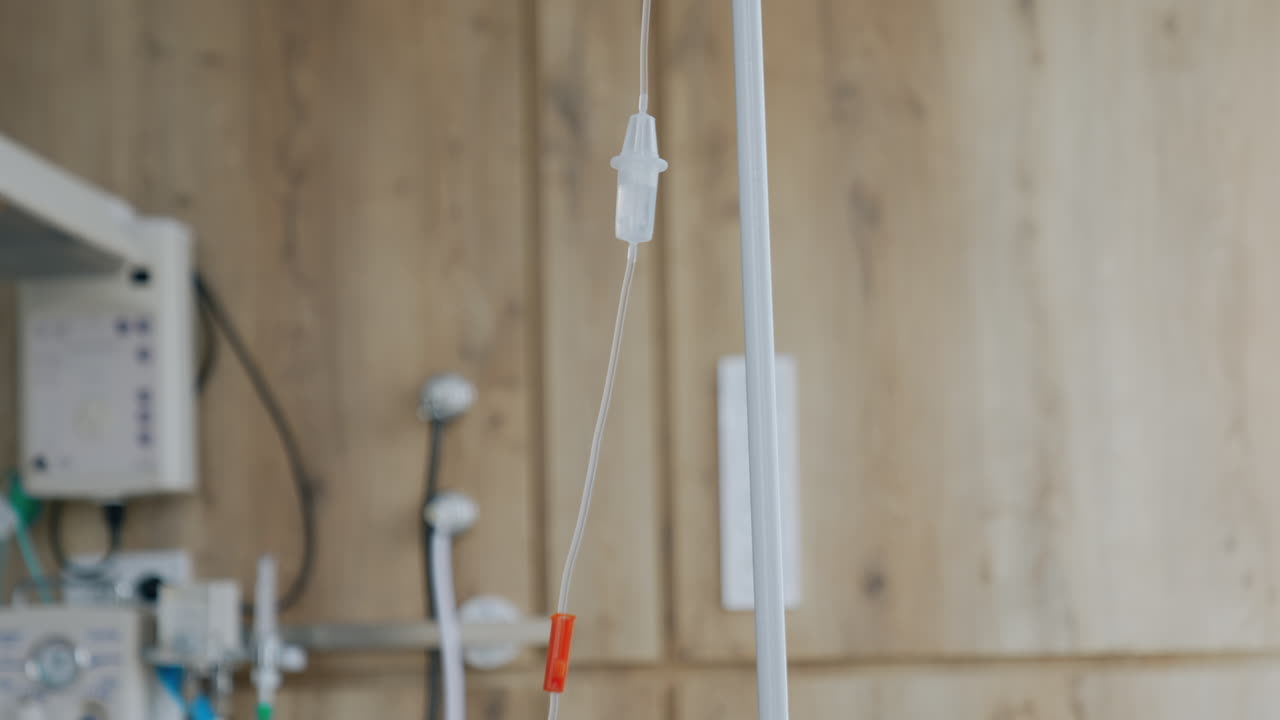 Stand with a drop counter in the modern delivery room. Empty bottle is connected to the dripping system. Low angle view.