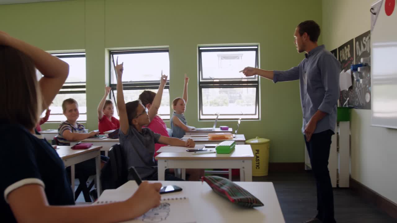 grupo de niños levantando las manos en la clase