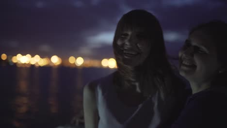 silueta de dos atractivas mujeres jóvenes que viajan en un barco por la noche. amigas en el barco