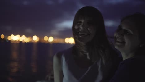 silhouette of two attractive young women traveling on a ship at night. girlfriends on the boat