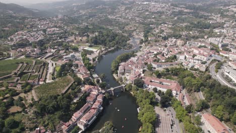 rooftops of amarante town surrounding tamega river, aerial ascend view