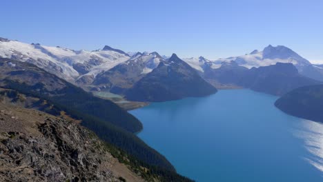 lago idílico rodeado de montañas nevadas con un ambiente brumoso