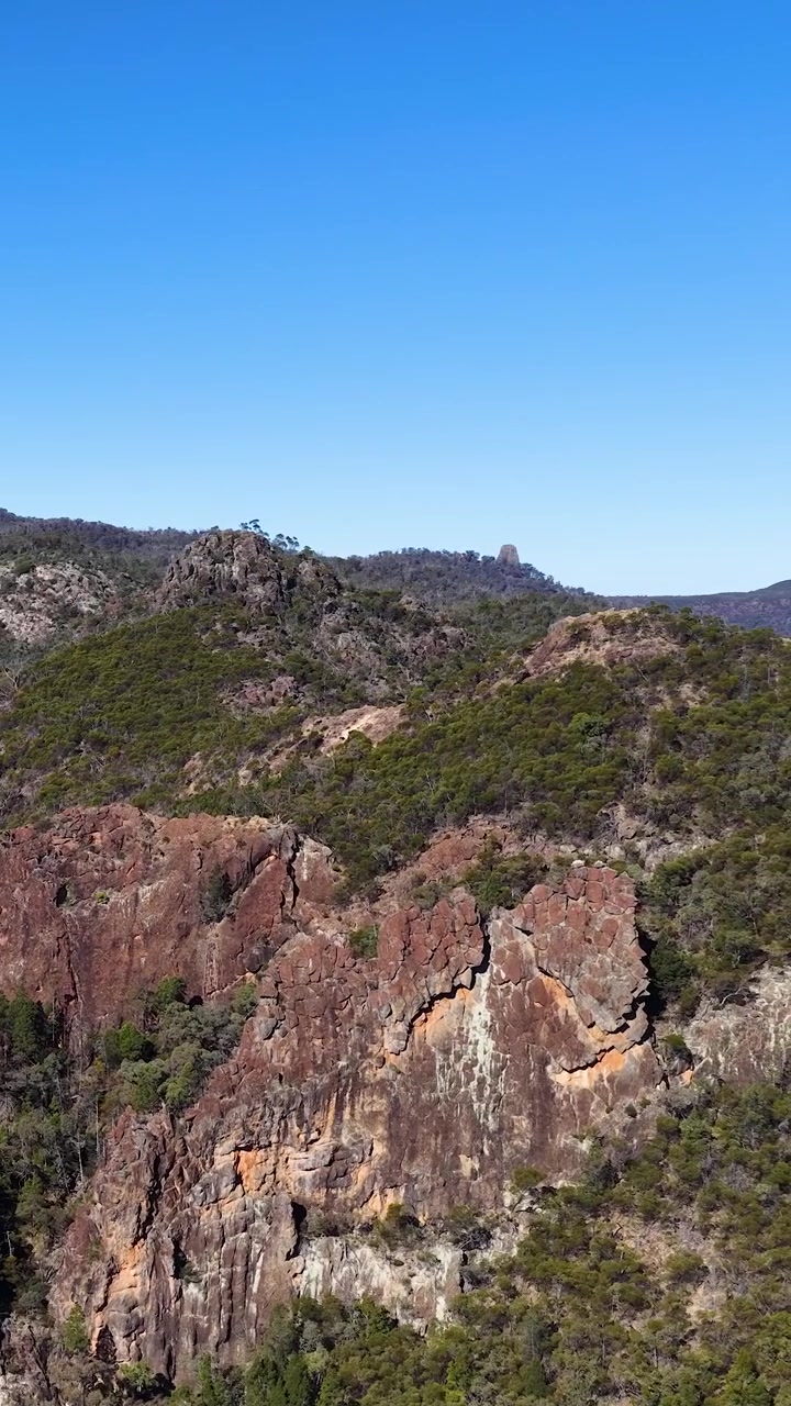 Inquadratura ampia di formazioni rocciose vulcaniche sotto un cielo azzurro e limpido nel Parco Nazionale di Warrumbungle