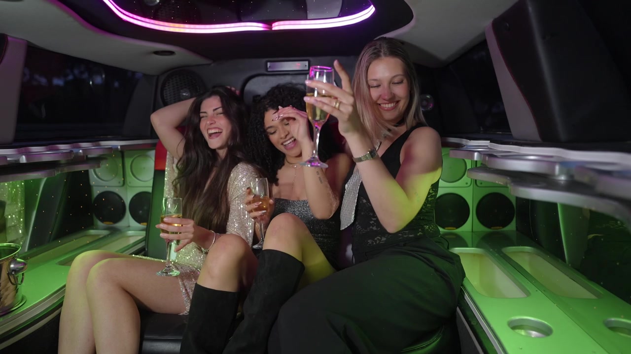 Tres mujeres jóvenes felices celebrando con champán en una limusina de lujo