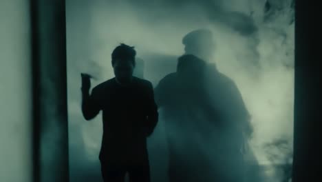 silhouettes of men in fog