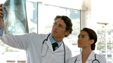 dos médicos serios mirando las radiografías