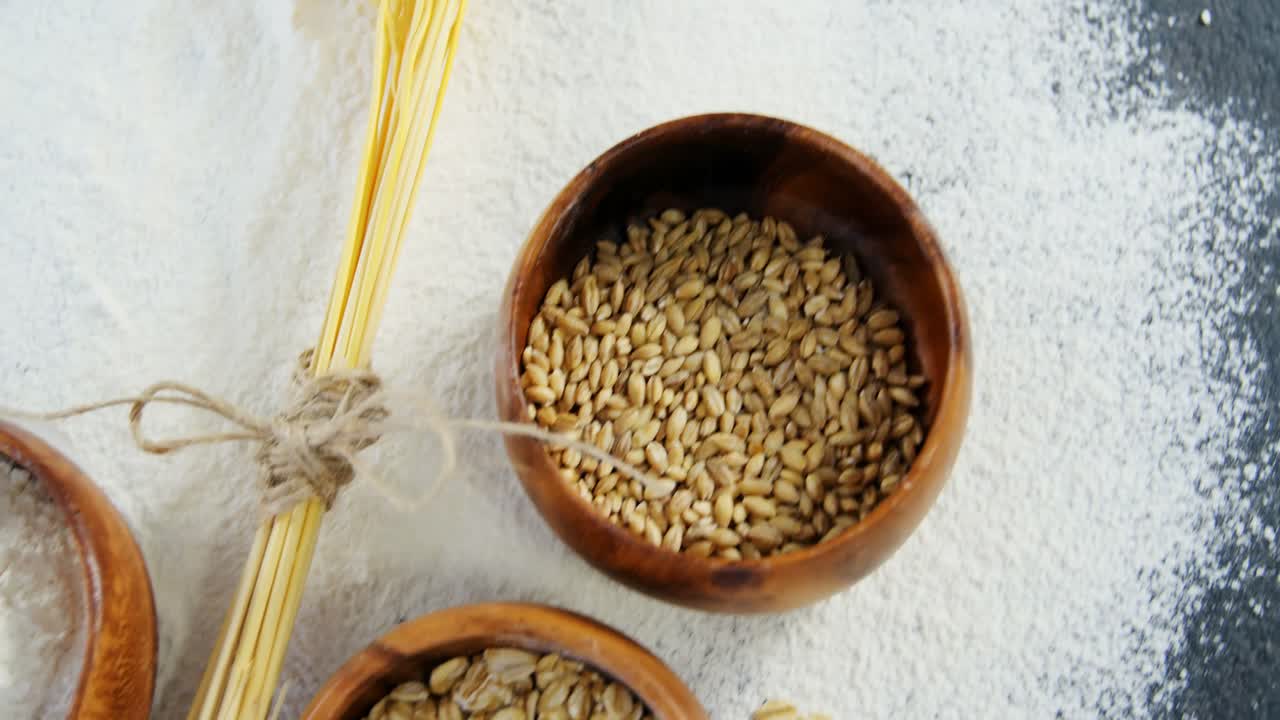 Wheat grains, sesame and flour in bowls