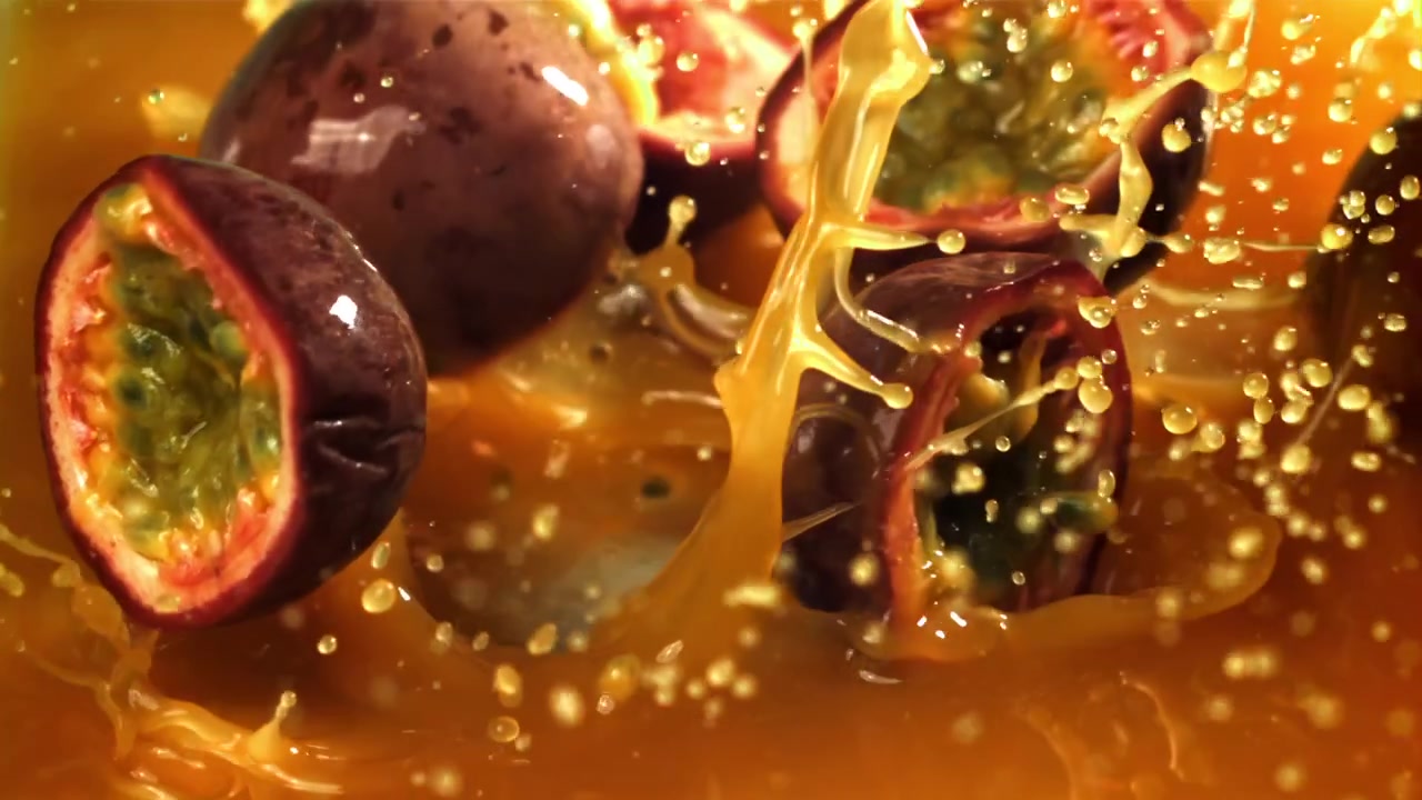 Frutti della passione freschi che schizzano nel succo d'arancia al rallentatore