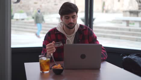 cheerful man making online payment via laptop