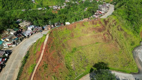 Idyllic-Flyover-of-Summit-View-Mountain-Park-in-Viga,-Catanduanes,-with-quaint-homes-lined-along-winding-roads-and-dense-jungle-in-background