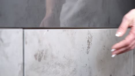 mujer con uñas pintadas abre y cierra el cajón del armario