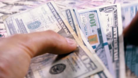 le mani degli uomini tengono un mucchio di dollari americani sullo sfondo di denaro in rotazione