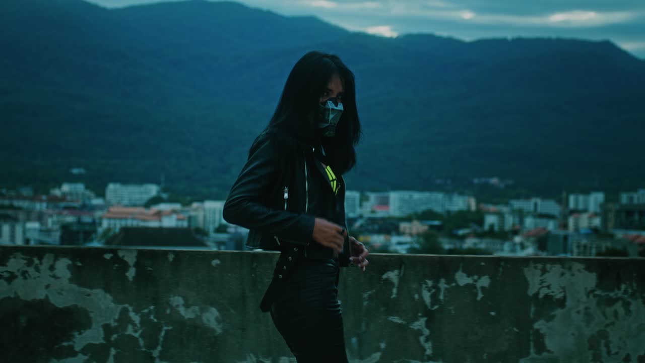 Woman in a black leather jacket on a rooftop at night