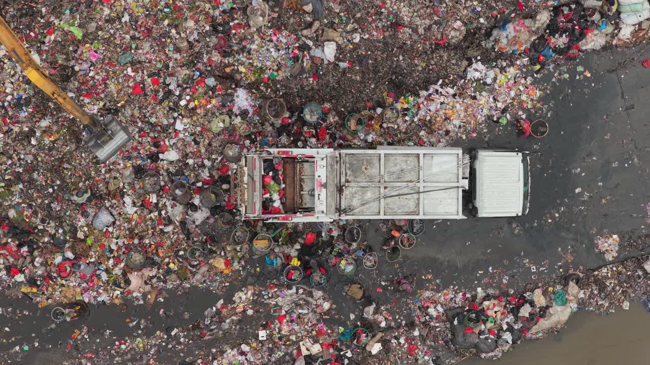 Camion dei rifiuti che scarica i rifiuti in una vasta discarica a Giacarta
