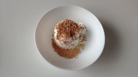a creamy serving of junket topped with toasted sesame seeds, perfect for dessert