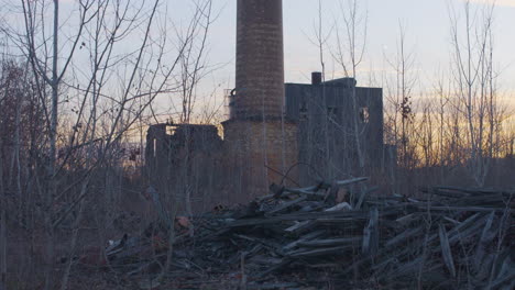 piles of used railroad ties in front of an abandoned industrial site