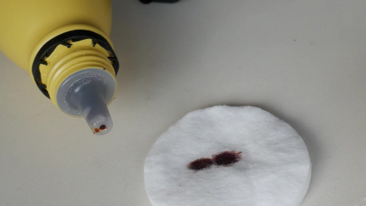 Žlutá lékařská lahvička s tryskou dávkující tekutinu na vatový tampón. Léčba infekce.