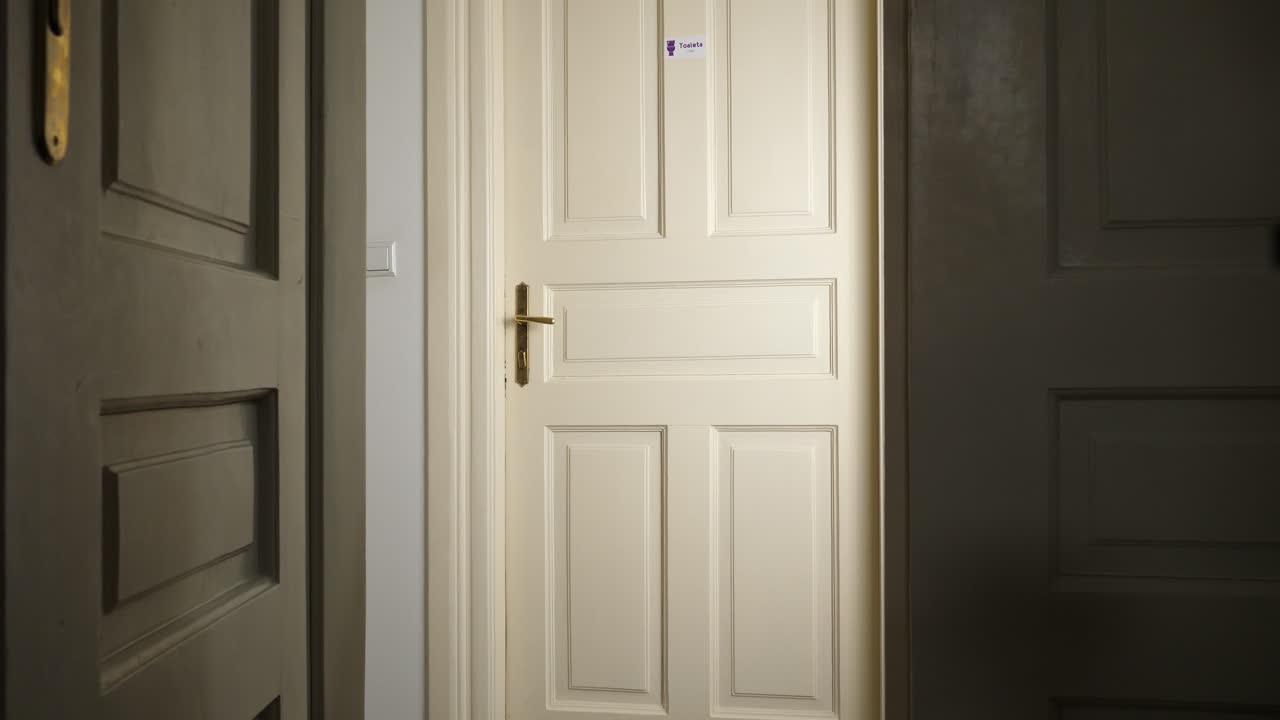 una mujer rubia corre al baño sosteniendo su trasero, cerrando la puerta.