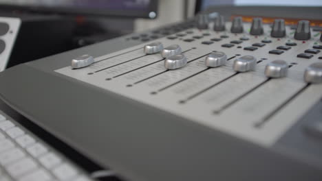 muévete por la mesa de mezclas de sonido mientras los faders se mueven solos