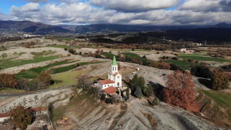 Antena:-Volando-Hacia-Una-Capilla-En-El-Campo-Catalán-Con-Nubes-Y-Montañas-Al-Fondo