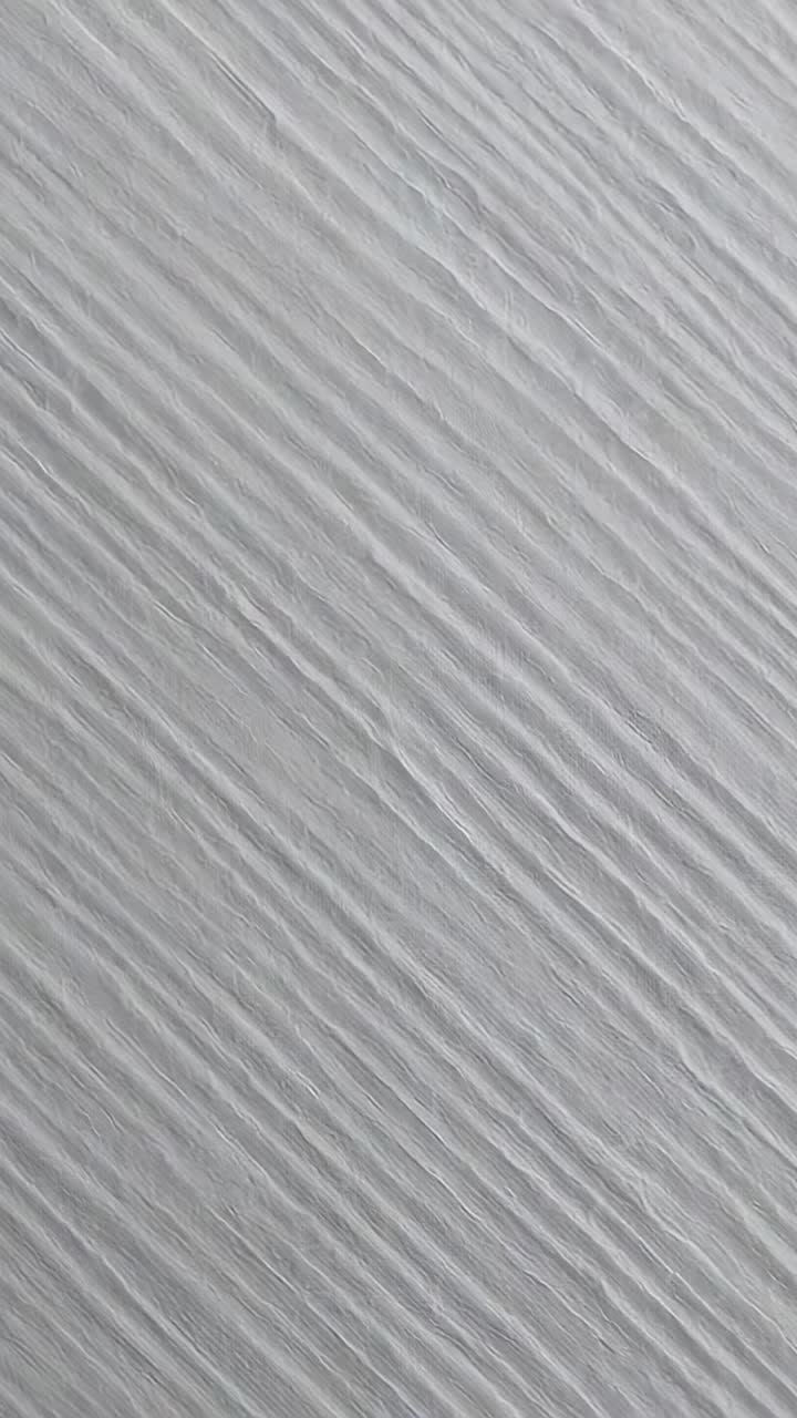Vertical video: Moving camera revealing gray textured wall inside, showing angled ridges for detail