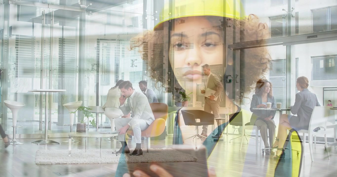 Donna con cappello giallo che tocca un dispositivo che avvia una dissolvenza incrociata che si sovrappone a una lobby aziendale che aggiorna i dati