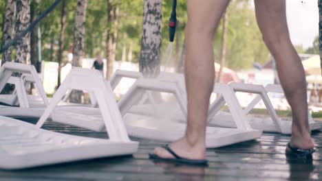 beach worker washes the beach loungers with a jet of water 1