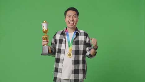 트로피와 메달로 승리를 축하하는 남자